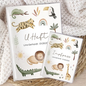 Könnte beinhalten: Zwei weiße Cover mit Dschungeltier-Illustrationen. Das größere Cover zeigt "U-Heft" und "Lina Gerhard: 01.08.20". Das kleinere Cover zeigt "Impfpass" und "Lina Gerhard: 01.08.2023".