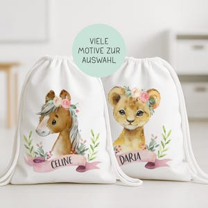 Könnte beinhalten: Zwei weiße Kordelzugbeutel mit Aquarellillustrationen. Einer zeigt ein braunes Pferd mit Blumenkrone und dem Namen "CELINE" auf einem rosa Banner. Der andere Beutel hat ein Löwenjunges mit Blumenkrone und dem Namen "DARIA". Der Text "VIELE MOTIVE ZUR AUSWAHL" befindet sich in einem grünen Kreis.