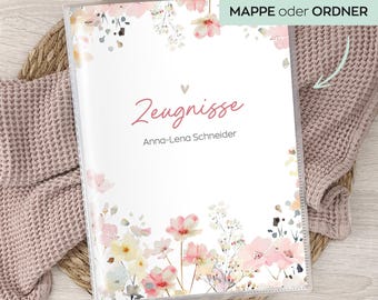 Pode incluir: Uma pasta de plástico transparente com um design floral com flores rosa e amarelas. A capa tem a palavra "Zeugnisse" em escrita cursiva, com o nome "Anna-Lena Schneider" abaixo. O texto "erhältlich als MAPPE oder ORDNER" está em um retângulo verde.