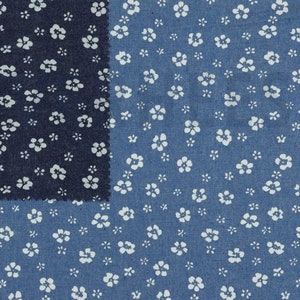 Könnte beinhalten: Nahaufnahme von zwei Stoffstücken mit einem weißen Blumenmuster auf blauem Jeansstoff. Das obere Stoffstück ist ein dunklerer blauer Jeans mit einem kleineren Blumenmuster.