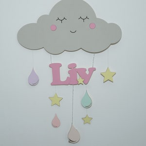 May include: A gray wooden cloud with a smiling face and pink cheeks hangs from the ceiling with pink, purple, and green raindrops and yellow stars. The name "Liv" is spelled out in pink letters below the cloud.