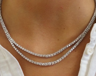 May include: A double row diamond tennis necklace with a silver chain.