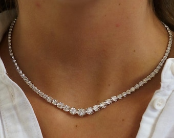 May include: A delicate diamond tennis necklace with a white gold chain. The necklace features round brilliant cut diamonds set in a prong setting.