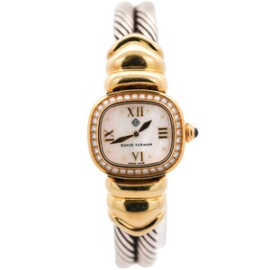 May include: A luxury wristwatch with a gold and silver band. The watch face is square with a white mother-of-pearl background, diamond-encrusted bezel, and gold Roman numeral hour markers. The watch is marked "DAVID YURMAN" and "SWISS MADE".