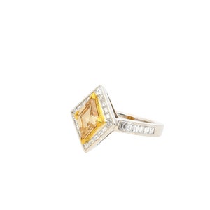 May include: A diamond ring with a square-shaped centre stone and a diamond band.