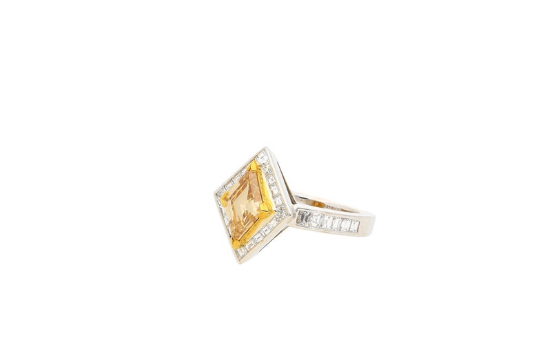 May include: A diamond ring with a square-shaped centre stone and a diamond band.