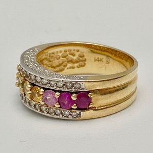May include: A gold band ring with a row of colorful gemstones and a row of diamonds. The ring is marked "14K" on the inside.