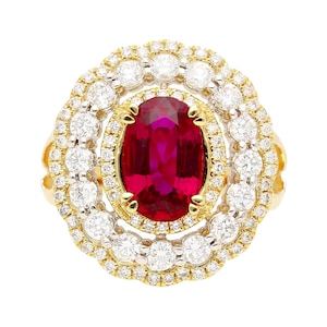 May include: A gold ring with a large oval ruby surrounded by a double halo of smaller diamonds.