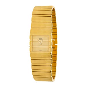 May include: A gold-toned Piaget wristwatch with a rectangular face and a matching, integrated band. The watch face features a minimalist design with gold hands and the Piaget logo. The band is composed of horizontal, rectangular links.