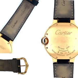 May include: A gold Cartier watch with a black leather band. The back of the watch has the words 'Cartier', '83119NX', '3003', 'AUTOMATIC', '750', 'WATER RESISTANT', 'SWISS MADE' engraved on it.
