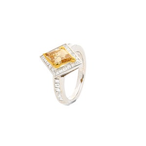 May include: A silver ring featuring a square yellow gemstone surrounded by smaller white gemstones.