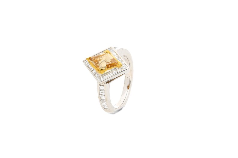 May include: A silver ring featuring a square yellow gemstone surrounded by smaller white gemstones.