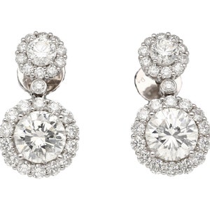 May include: A pair of silver drop earrings featuring a large round diamond surrounded by smaller diamonds. The earrings have a smaller diamond halo above the larger diamond.