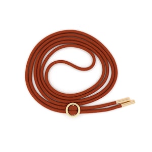 Op de afbeelding: Een bruine koordketting met een gouden cirkelhanger en twee gouden koorduiteinden.