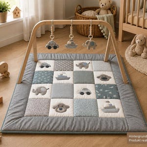 Könnte beinhalten: Eine rechteckige Baby-Spielmatte mit einem Patchwork-Design in Grau-, Blau- und Weißtönen. Die Matte verfügt über einen Holzbogen mit drei hängenden Plüschspielzeugen in Form eines Autos, eines Bootes und eines Elefanten.