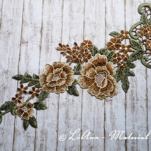 Könnte beinhalten: Eine braune und grüne florale Spitzenapplikation mit einem zarten Design. Die Applikation zeigt große und kleine Blumen mit filigranen Details. Sie ist perfekt, um jedem Projekt einen Hauch von Eleganz zu verleihen.