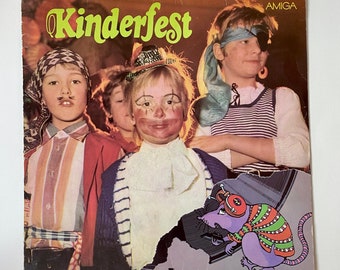 Puede incluir: Una portada de álbum de vinilo vintage con un grupo de niños vestidos con disfraces. El álbum se titula "Kinderfest" y presenta el logotipo de Amiga. La portada incluye una ilustración colorida de una rata con un sombrero y una camisa a rayas.