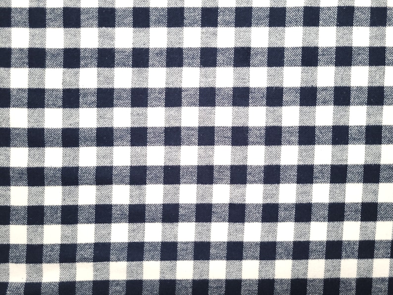 May include: A white and navy blue checkered fabric with a woven texture.