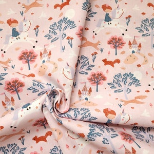 Könnte beinhalten: Rosafarbener Stoff mit einem sich wiederholenden Muster aus Mädchen, die auf Einhörnern reiten, Füchsen, Bäumen und Schlössern. Der Stoff hat ein verspieltes und märchenhaftes Design.