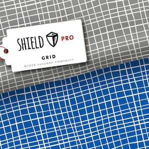 Könnte beinhalten: Ein weißes Etikett mit dem Text "SHIELD PRO GRID ©2020 SUSANNE FIRMENICH" auf einem grauen und weißen Gitterhintergrund. Das Etikett hat eine rote Schnur daran befestigt. Der Hintergrund ist ein graues und weißes Gittermuster. Das Etikett liegt auf einem blauen und weißen Gittermuster.