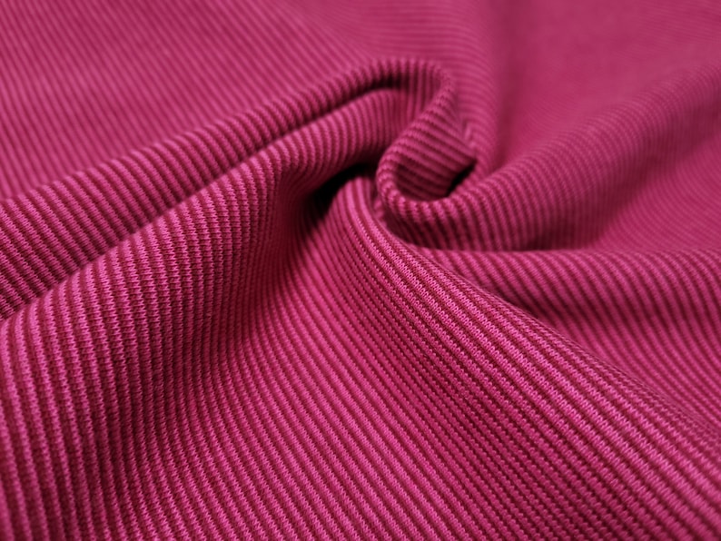 Peut inclure: Gros plan sur un tissu c&ocirc;tel&eacute; rose avec une surface textur&eacute;e.