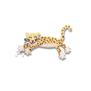 Könnte beinhalten: Gestickter Aufnäher mit einem Cartoon-Leoparden in Laufpose. Der Leopard ist gelb mit braunen Flecken und schwarzen Schnurrhaaren. Der Aufnäher hat den Text "JatiJu" in der unteren linken Ecke.
