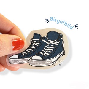 Könnte beinhalten: Aufkleber mit marineblauen High-Top-Sneakern mit weißen Schnürsenkeln und weißer Sohle. Der Aufkleber trägt den Text "Bügelbild" in Hellblau und die Signatur "JatiJu".