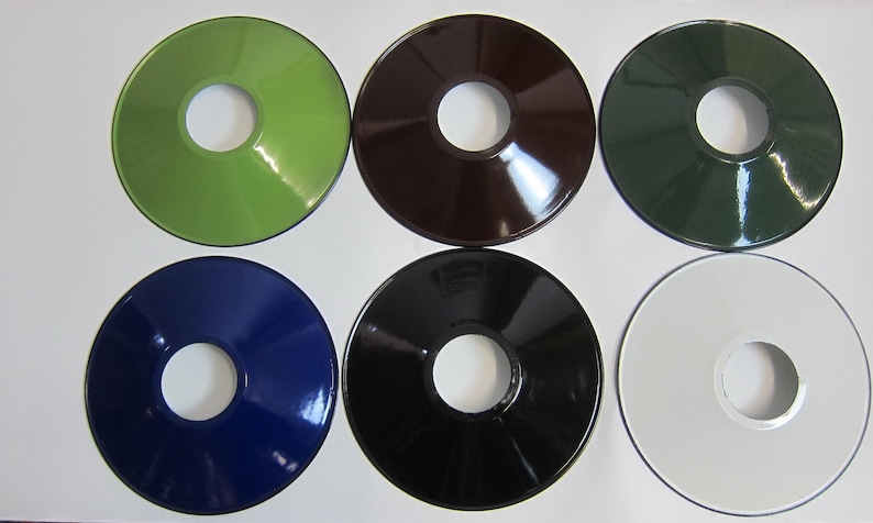 May include: Six round metal lampshades in different colors: green, brown, dark green, blue, black, and white. Each lampshade has a hole in the center.