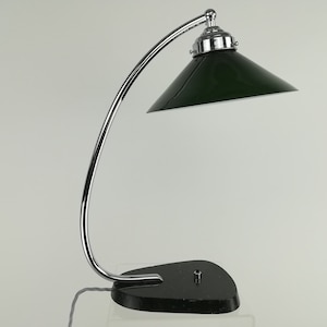 May include: A chrome desk lamp with a green shade. The lamp has a curved arm and a round base.