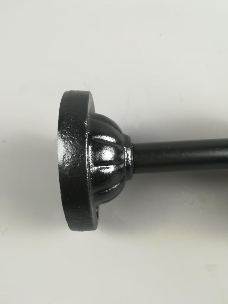 May include: Black metal curtain rod finial with a decorative fluted design.