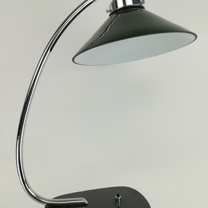 May include: A chrome desk lamp with a green glass shade and a black marble base.
