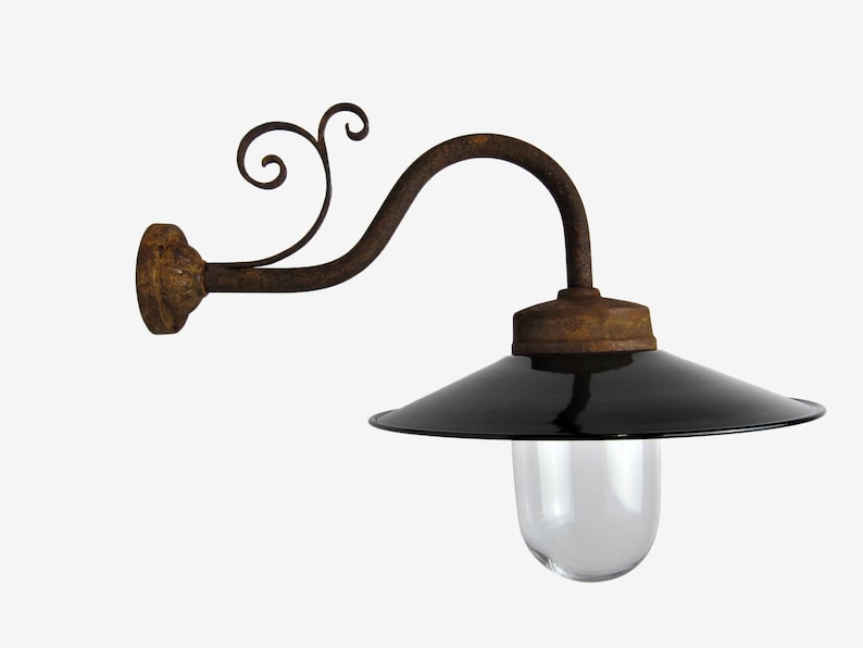 May include: A black and rusty metal wall sconce with a black enamel shade and a clear glass globe. The sconce has a decorative scroll design on the arm.