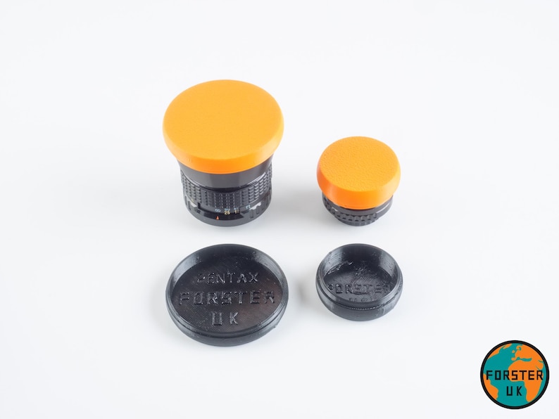 May include: Four camera lens caps, two orange and two black. The black caps have the text "PENTAX FORESTER ДК" printed on them.