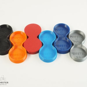 May include: Five 3D printed filter holders for small camera lenses. The holders are in black, orange, red, blue, and grey. Each holder has the text "Mamiya C Small" and "Forster UK" printed on it.