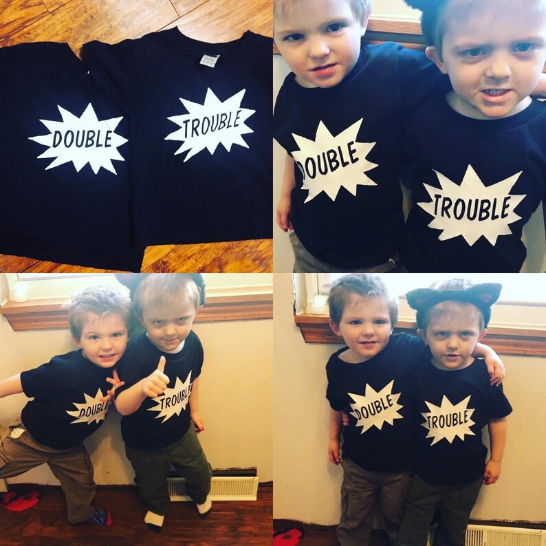 May include: Two children wearing black t-shirts with white text. One shirt says "Double Trouble" and the other says "Trouble".
