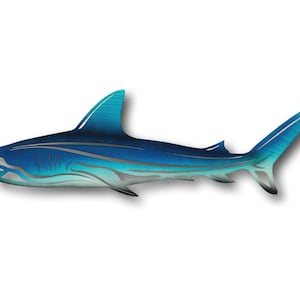 Peut inclure: Une décoration murale en métal représentant une silhouette de requin bleue et turquoise. Le requin est tourné vers la gauche et a un design stylisé.