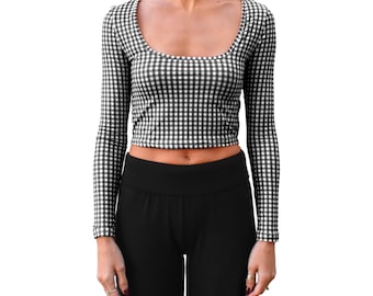 Könnte beinhalten: Ein schwarz-weiß kariertes Crop-Top mit langen Ärmeln und einem Rundhalsausschnitt. Das Oberteil wird mit einer schwarzen Hose kombiniert. Das Muster des Oberteils ist ein klassisches Karomuster. Das Outfit ist für Freizeitkleidung geeignet.