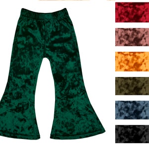 May include: Green velvet bell bottom pants for kids. The pants have a wide leg opening and a comfortable elastic waistband.