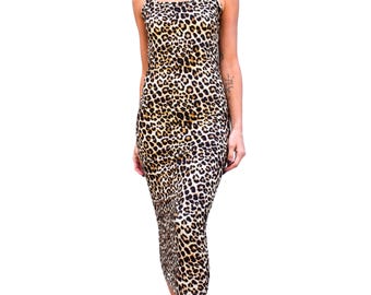 May include: A midi-length dress with a leopard print pattern. The dress features thin spaghetti straps and a fitted silhouette. The fabric is a mix of tan, brown, and black, creating a classic animal print design. The dress is suitable for various occasions.