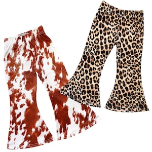 May include: Two pairs of girls' bell bottom pants. One pair is brown and white cow print and the other is brown and black leopard print.