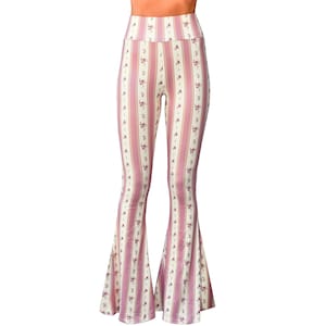May include: High-waisted, flared pants with a vertical stripe pattern in pink and cream. The stripes are interspersed with a delicate floral print. The pants have a fitted upper portion that flares out from the knees.