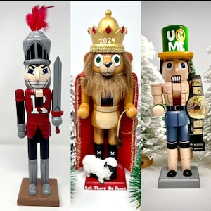 May include: Three wooden nutcrackers. The first is a soldier in a red uniform with a silver helmet and sword. The second is a lion wearing a gold crown and red cape. The third is a wrestler with a championship belt and a green hat.