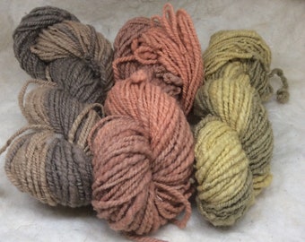 Handspun garens verpakking, rood, bruin, groene scheefen. Pure schapenwol. Wol voor het breien. Niet super wassen garen. Duurzame wol. Handgeverfde garens