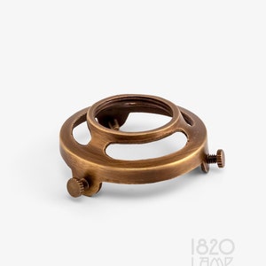 May include: A brass lamp socket with three screw holes. The socket is designed to hold a light bulb.