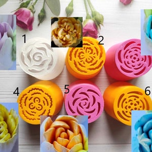 Pode incluir: Seis moldes de silicone redondos para fazer flores de manteiga. Os moldes são de várias cores, incluindo branco, amarelo, rosa e laranja. Os moldes apresentam diferentes designs, incluindo um redemoinho, uma flor e uma estrela.