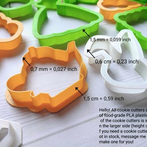 May include: A selection of colourful cookie cutters in orange, green, and white. The image shows the dimensions of the cutters in millimetres and centimetres. The text in the image says, "Hello! All cookie cutters are made of food-grade PLA plastic."