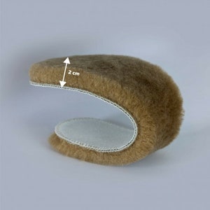 Peut inclure: Un chausse-pied en peau de mouton marron avec une doublure en feutre blanc. Le chausse-pied mesure 2 cm de large.
