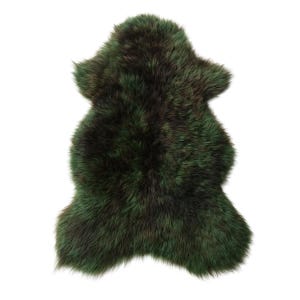 Puede incluir: Una alfombra de piel de oveja verde oscuro con forma natural. La alfombra tiene un aspecto denso y texturizado con variaciones de color, incluyendo tonos de verde y marrón. La alfombra se muestra sobre un fondo blanco.