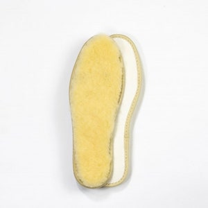 Peut inclure: Une paire de semelles en peau de mouton beige avec une doublure blanche. Les semelles sont con&ccedil;ues pour apporter chaleur et confort.