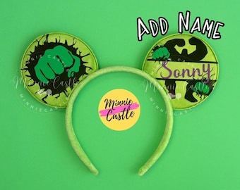 May include: Green and black Minnie Mouse ears with a Hulk fist graphic and the text "Sonny" on one ear. The other ear has a green and black Hulk fist graphic. The ears are on a green background with a yellow circle with the text "Minnie Castle" in pink.